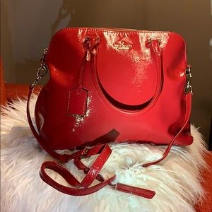 Red patent leather Kate Spade bag with dust cover